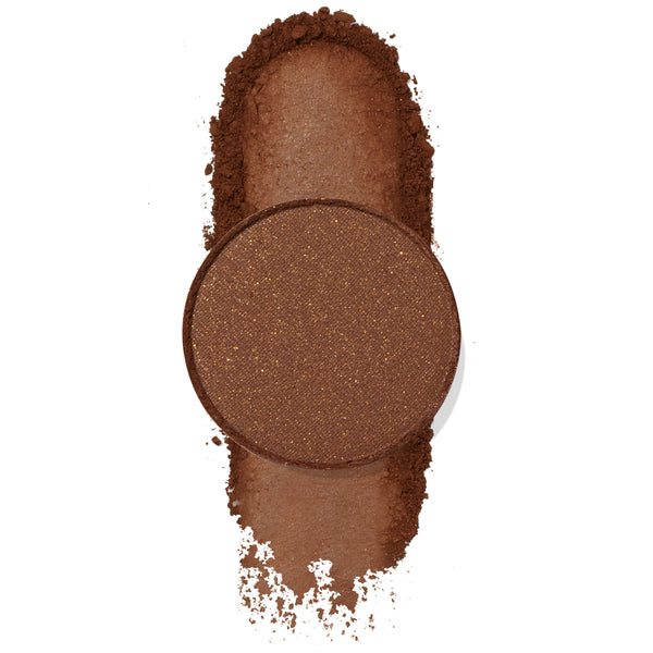 Single round copper-brown eyeshadow with gold flecks resting on a swatched trail of loose pigment on white, showcasing Mission, a ColourPop Pressed Powder Shadow.