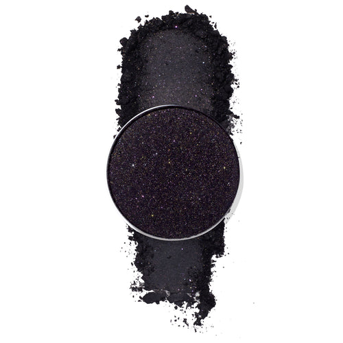 ColourPop Nightdream pressed powder shadow pan showcasing a deep black‑purple eyeshadow packed with fine multicolor sparkle, displayed with a crushed swatch on a white background, highlighting its glittery smoky finish.