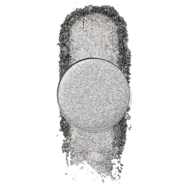 On a Whimsy pressed powder shadow by ColourPop, a cool-toned metallic silver single pan, catching light as the shade is swatched in a dense shimmer trail with loose glittery pigment on a white background.