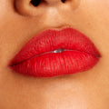 Lips wearing Overtime, a ColourPop Lippie Pencil, lining and filling the mouth in a vivid true red with a soft matte finish; close-up beauty shot highlights crisp edges and even color payoff on warm-toned skin.
