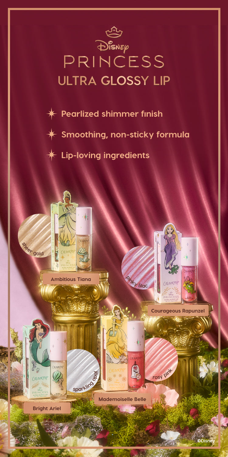 Colourpop Disney Princess Ultra Glossy Lip collection displayed on ornate gold pedestals against a burgundy satin backdrop, featuring Ariel, Tiana, Belle, and Rapunzel themed lip gloss tubes in sheer gold, pinky lilac, sparkling opal, and rosy pink shades.