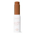 ColourPop Pretty Fresh Tinted Foundation Balm, shade Dark 20, stands uncapped with the twist-up stick exposed in a deep warm brown, housed in a white tube labeled Pretty Fresh against a clean white background.