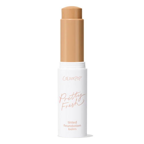 ColourPop Pretty Fresh Tinted Foundation Balm in Medium Dark 13 twists up from a white tube with blush pink “Pretty Fresh” script, cap removed, revealing a medium-dark tan balm stick against a plain white background.