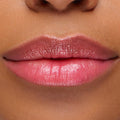Glossy lips wearing Sing, a ColourPop pH Lip Balm, reveal a soft rosy pink tint that adapts to skin pH, with smooth, hydrated shine in a close-up lip swatch.