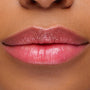 Glossy lips wearing Sing, a ColourPop pH Lip Balm, reveal a soft rosy pink tint that adapts to skin pH, with smooth, hydrated shine in a close-up lip swatch.
