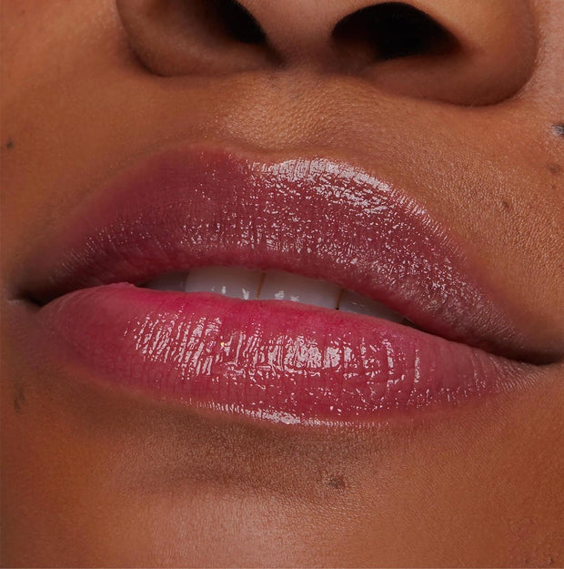 Glossy lips wear Thunderbolt pH Lip Balm, showing a sheer berry-pink tint that adjusts to pH with high shine; close-up swatch for ColourPop pH Lip Balm shade reference.