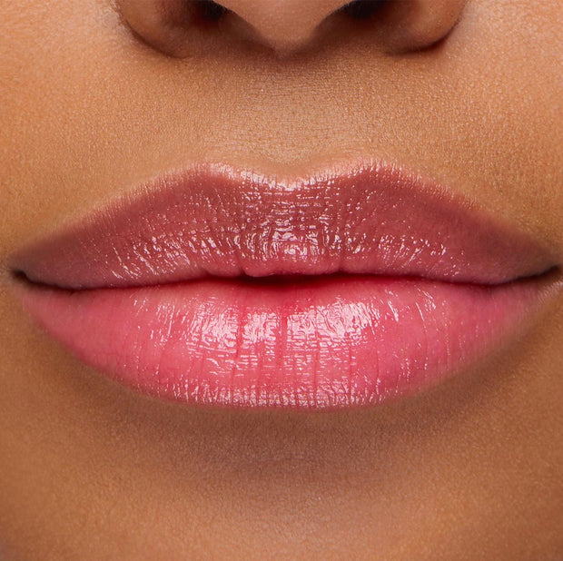 Glossy lips wearing Thunderbolt pH Lip Balm, a pH-activated balm that shifts to a custom rosy pink with high shine and hydration; close-up swatch showcases the sheer, buildable color of the ColourPop pH Lip Balm.