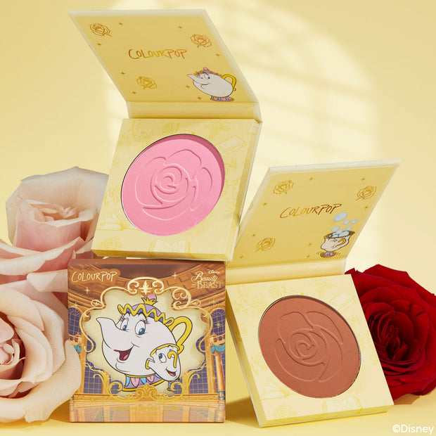 Chip ColourPop Pressed Powder Blush compact opens to reveal a rose-embossed bright pink pan, showcased with Beauty and the Beast Mrs. Potts and Chip packaging beside a second warm rose shade and fresh roses on a soft yellow backdrop.