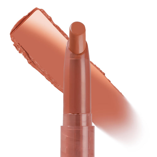 ColourPop Parker Lippie Stix uncapped and angled for application, with a smooth warm peachy nude swatch behind the sleek tube on a white background, highlighting the creamy lipstick texture.