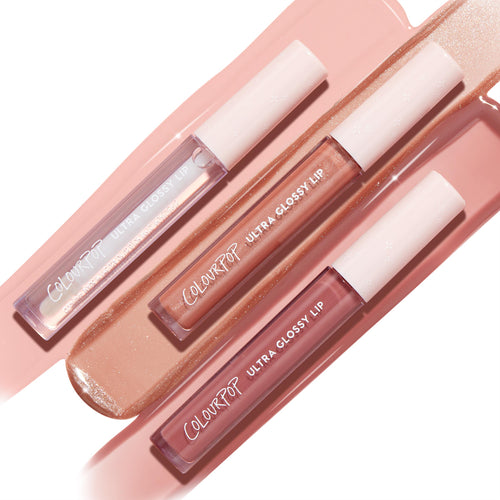 Perfect 4 U ColourPop Ultra Glossy Lip trio displays clear shimmer, peachy nude sparkle, and rosy mauve tubes with star-detailed white caps, laid diagonally on glossy pink and champagne swatches to show the high-shine, cushiony finish.