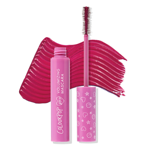 ColourPop BFF Mascara Pink Inc. wand lifted from an open hot-pink tube, showing a volumizing brush coated in vibrant fuchsia pigment, with bold swatch strokes behind on a white background; playful icon-print cap highlights the shade and packaging.