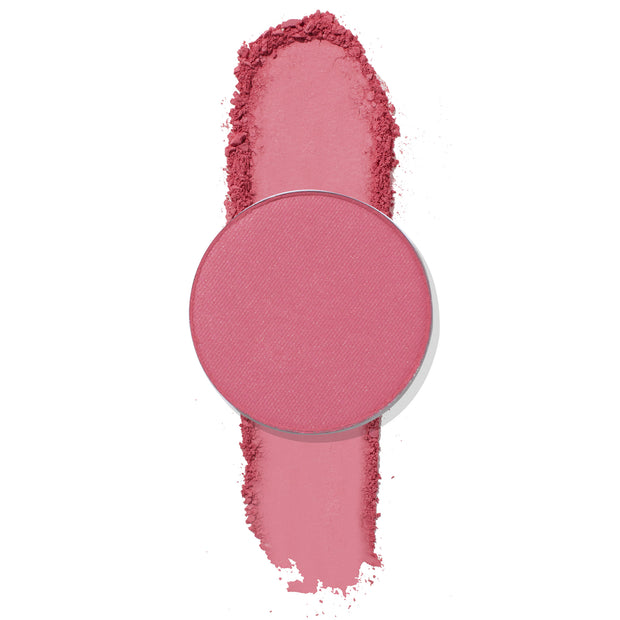 ColourPop Poodle pressed powder eyeshadow, a round single pan in matte rosy pink, sits atop a vertical swatch with soft crumbled edges, showcasing smooth, blendable pigment on a clean white background.