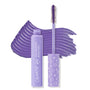 Purple Prose ColourPop BFF Mascara shown open, wand coated in rich violet sweeping across a bold swatch, beside a lavender volumizing tube and a cap with hearts, stars, and smiley icons on a white background.
