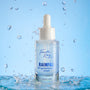 Fourth Ray Beauty Rainfall 2% HA Serum dropper bottle standing upright, catching water splashes against a light-blue backdrop, showcasing its hydrating hyaluronic acid formula; ColourPop Face Serum, 0.95 fl oz/28 mL.
