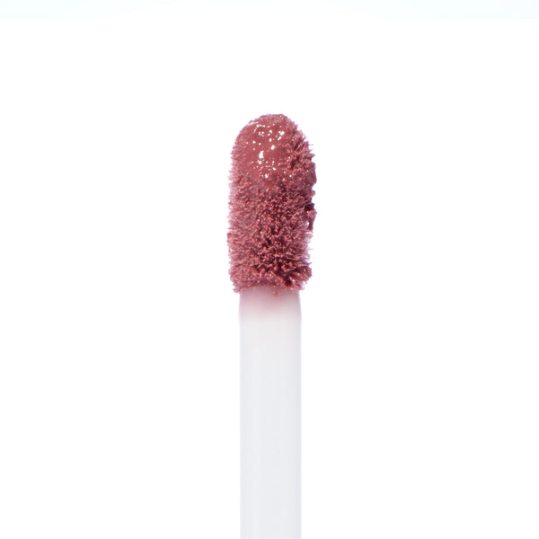 Doe-foot applicator swiping Rose Latte Ultra Blotted Lip, a rosy mauve-brown shade with a soft blurred finish, against a white background; ColourPop Ultra Blotted Lip macro highlighting plush bristles and creamy texture.
