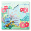 Ohana ColourPop Super Shock Highlighter compact displayed in a teal Disney Lilo & Stitch box, star-shaped window revealing the pan and holographic Stitch art, framed by red hibiscus and palms; 4.0 g (0.14 oz) collab makeup.