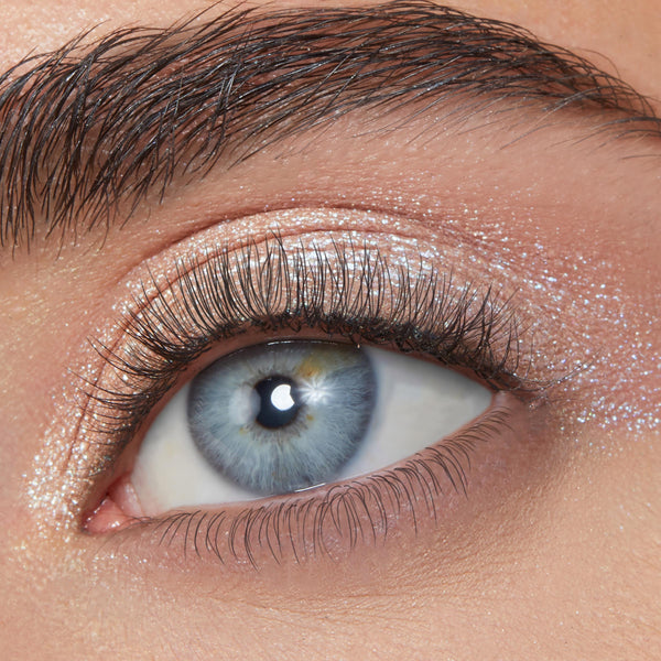 ColourPop Sailor Super Shock Shadow, a shimmery icy silver with blue reflects, swept across the eyelid and inner corner, catching light; close-up of an eye with natural lashes highlights the high-shine, sparkly finish.