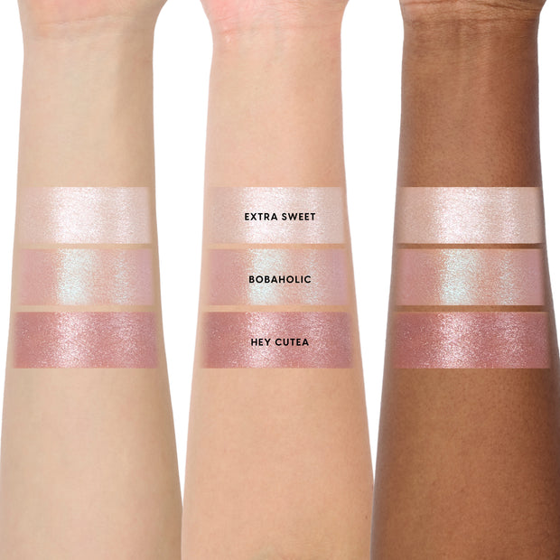 Three arms in different skin tones display the Sweet Sips full collection set of Super Shock Shadow swatches, showing shimmery shades Extra Sweet, Bobaholic, and Hey Cutea in metallic pink and champagne hues for comparison across skin tones.