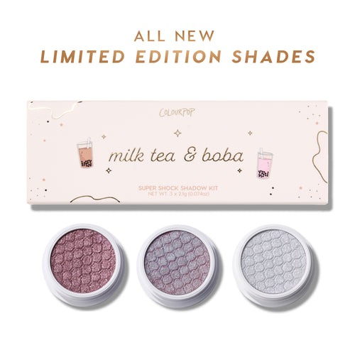 ColourPop Milk Tea and Boba Super Shock Shadow trio displayed with open pans of shimmery mauve, lavender, and icy silver shades beneath a pink limited edition Super Shock Shadow kit box decorated with boba tea illustrations on a white background.