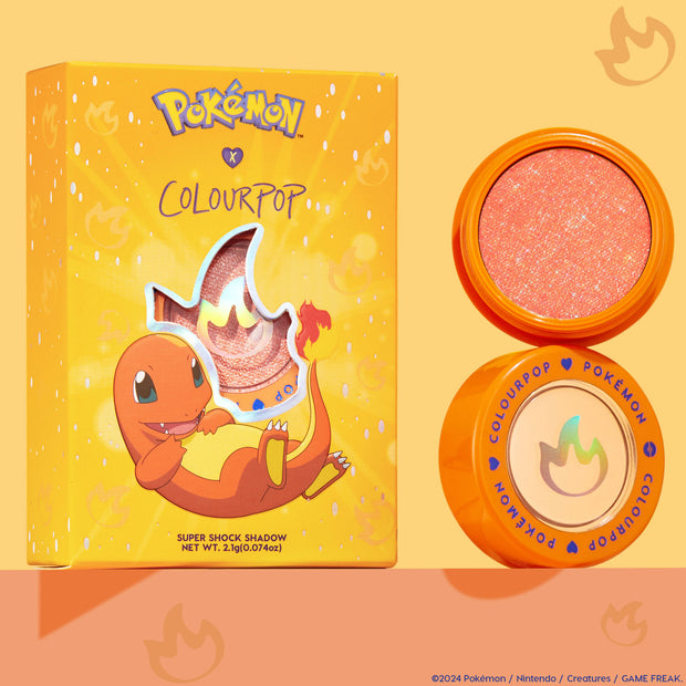 ColourPop Super Shock Shadow in Flamethrower, a sparkly peach‑orange metallic eyeshadow, shown open in an orange pot beside the Pokémon x ColourPop box featuring Charmander and a flame cutout, on a warm peach background.