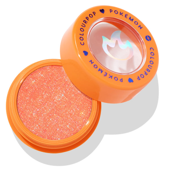 Flamethrower Super Shock Shadow opens to reveal a sparkly orange‑coral eyeshadow in an orange pot, topped with a clear lid showing a holographic flame and blue ColourPop Pokémon lettering; ColourPop Super Shock Shadow single.
