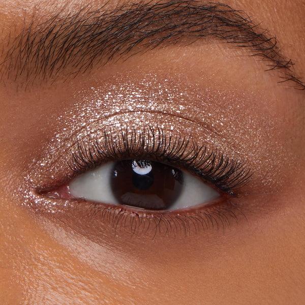 Mighty Morphin' ColourPop Super Shock Shadow shimmering across a brown eye, a metallic champagne wash with fine glitter payoff and smooth blend, close-up of the eyelid to show sparkle and creamy texture.