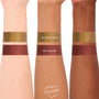 We Won’t Bite swatched in thick bands on three arms, showing a metallic olive-gold ColourPop Super Shock Shadow with high shimmer, stacked above The Volturi deep burgundy shade to compare payoff across light, medium, and deep skin tones.