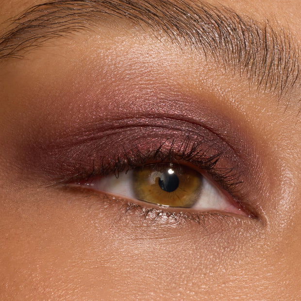 Shimmery plum‑burgundy eyeshadow sweeps across the lid and crease, showing the payoff and blend of The Volturi Super Shock Shadow on a close-up eye with defined lashes; ColourPop Super Shock Shadow finish reads metallic with a soft satin sheen.