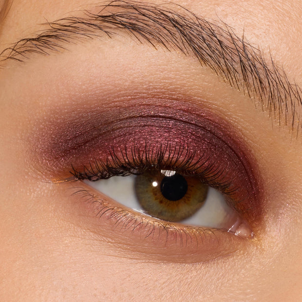 The Volturi ColourPop Super Shock Shadow swept across the lid, a metallic burgundy-plum shimmer blended into the crease on a hazel eye with natural lashes, highlighting smooth, high-pigment payoff and softly diffused edges.