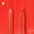 ColourPop Lippie Pencil in Chi Chi stands upright with a sharpened tip beside a matching lippie stick on a vivid orange-red swatched background with sparkles and a ColourPop heart logo, showcasing the bold coral-red shade.