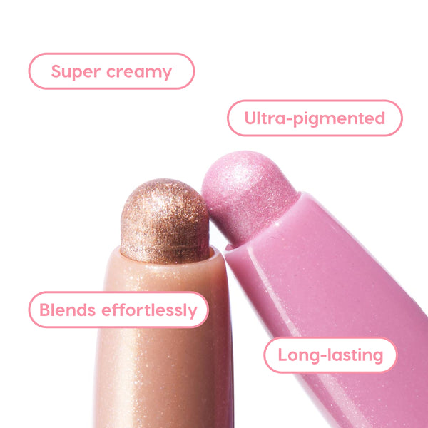 Two shimmery ColourPop Shadow Stix, Cool Metallics - rose gold and icy pink - display rounded glide tips, delivering creamy, ultra-pigmented color that blends effortlessly and lasts long, shown in nude and pink tubes on a white background.