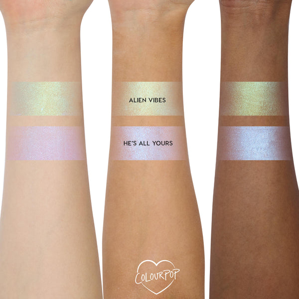 ColourPop Shadow Stix Cute and Feisty swatched on three arms - two bands per arm labeled Alien Vibes (gold‑green shimmer) and He’s All Yours (pink‑lilac blue shift) - showing creamy payoff across light, medium, and deep skin tones.