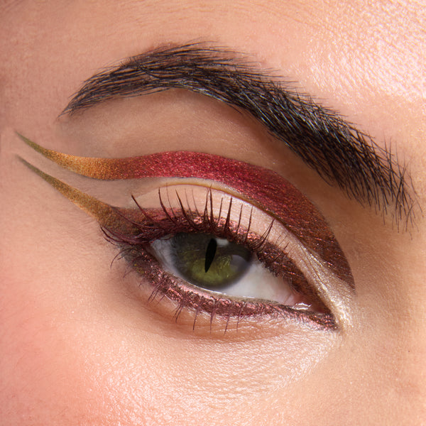 Metallic winged eye makeup showcasing a shimmering red band with gold-to-olive gradient liner and cut-crease, captured close-up to show sparkle and precision from the ColourPop X DreamWorks Shrek Full Collection Set, a ColourPop Full Collection Set.