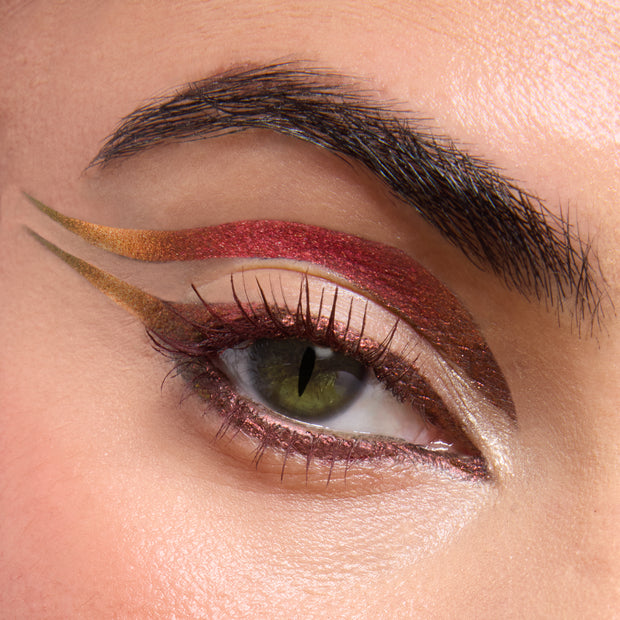 Metallic winged eye makeup showcasing a shimmering red band with gold-to-olive gradient liner and cut-crease, captured close-up to show sparkle and precision from the ColourPop X DreamWorks Shrek Full Collection Set, a ColourPop Full Collection Set.