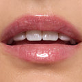 Glossy lips wearing ColourPop Ultra Glossy Lip in Totally Swamped, a sheer pink shimmer with fine sparkle, reflecting high shine in a studio close-up to showcase the smooth, hydrated finish.