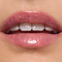 Glossy lips wearing ColourPop Ultra Glossy Lip in Totally Swamped, a sheer pink shimmer with fine sparkle, reflecting high shine in a studio close-up to showcase the smooth, hydrated finish.