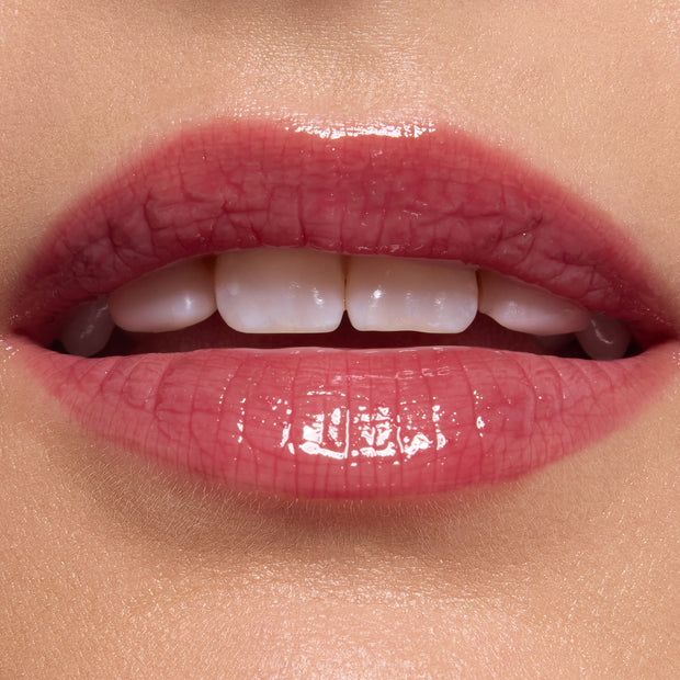 Glossy pink lips wearing ColourPop Ultra Glossy Lip, shade Short Lord, delivering a sheer rosy tint with mirror-like shine; close-up beauty swatch on smooth skin highlights the plush texture and reflective finish.