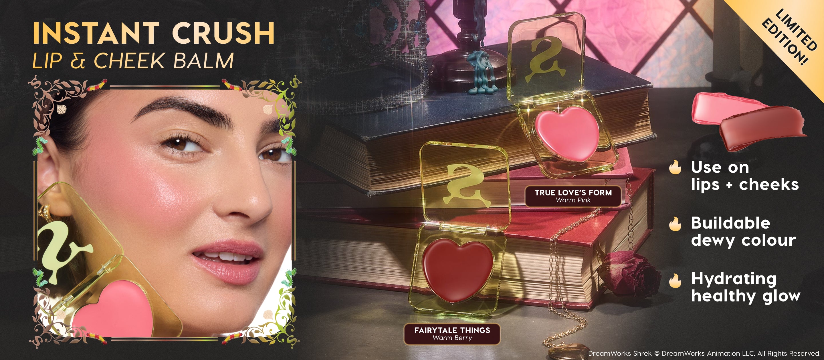 Close-up model wears dewy pink blush while showcasing Shrek Instant Crush Lip & Cheek Balm, with heart-shaped compact pans in warm pink and warm berry shades styled on stacked fairytale books in a magical vanity setting, highlighting buildable hydrating glow.