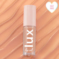 ColourPop Lux Lip Oil Skinny Dip tube resting on glossy peach swirls, showcasing a clear bottle with vertical 'lux' logo and pale pink cap with star motifs, plus a heart 'Cult Fave' badge in the corner.