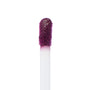 Doe-foot applicator coated in So Vintage, a deep berry-plum ColourPop Ultra Blotted Lip, lifting pigment with a soft, fuzzy tip against a white background, highlighting the saturated color for precise application.