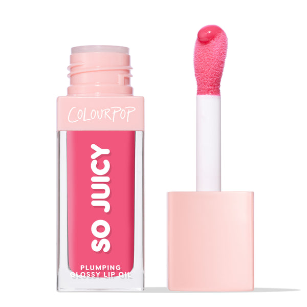 ColourPop So Juicy Plumping Glossy Lip Oil in Trending Now, a vibrant hot pink, stands upright with the cap off as a cushioned doe-foot applicator holds a bead of gloss beside the clear rectangular tube with pale pink cap on a white background.