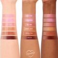 Tini Time shade swatch shines on three forearms, centered among labeled shades, showing a glossy pink‑nude glow; part of ColourPop So Juicy Plumping Gloss Balm with Peptides lineup on a white studio background.