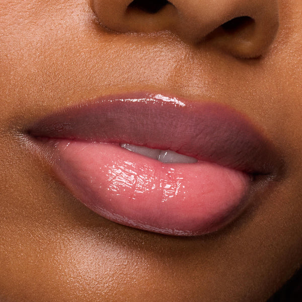 Glossed lips subtly parted, showcasing Forbidden Love, a rosy pink shade of the ColourPop So Juicy Plumping Gloss, delivering a plumped, high-shine wet look in a close-up studio beauty shot.