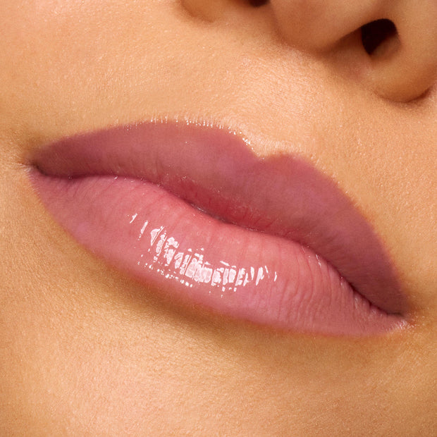 Glossy lips wearing Forbidden Love, a sheer rosy-mauve shade of ColourPop So Juicy Plumping Gloss, reflecting high shine in an extreme close-up swatch that highlights a smooth, hydrated, subtly plumped finish.