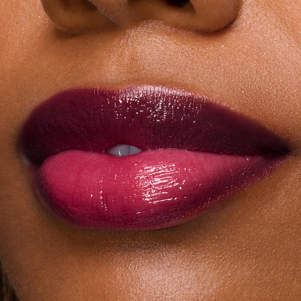 Glossy lips wearing ColourPop So Juicy Plumping Gloss in Temptation, showcasing a deep berry‑pink ombré shine and glassy, plumped finish in a tight close-up beauty shot.