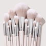 Soft pink makeup brushes with silver ferrules fan upright, showcasing powder, blush, and eyeshadow heads in a neat cluster on a neutral backdrop, part of The Ultimate Stunner ColourPop Shadow Palette & Brush Set for precise application.