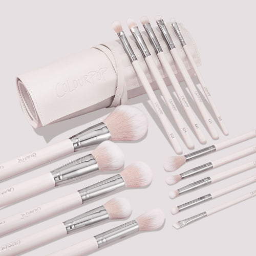 Metallic Mood ColourPop Shadow Palette & Brush Set displayed with a blush-pink brush roll; soft pink handles with silver ferrules and fluffy face plus precision eye brushes labeled E1–E8 are fanned on a light background, logo embossed on the roll.
