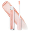 ColourPop Ultra Glossy Lip in Sugar Cookie stands with its wand uncapped, doe-foot applicator coated in peachy nude shimmer, set over a wide swatch of sparkling gloss; clear tube and blush star-print cap highlight the high-shine finish.