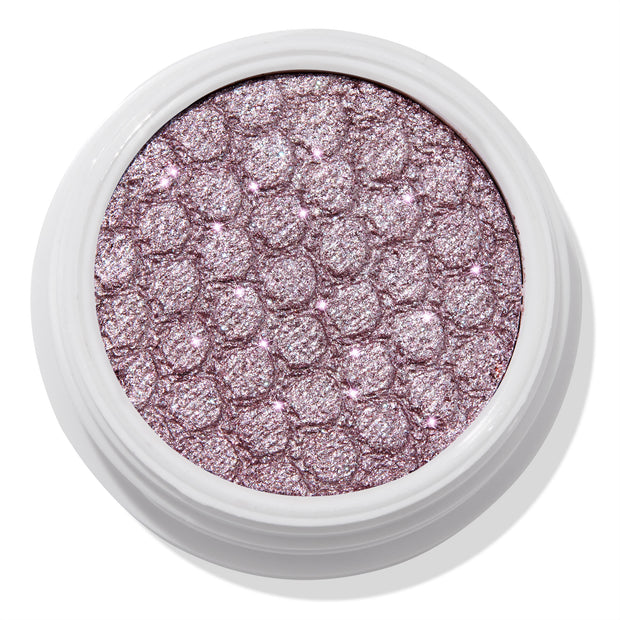 ColourPop The Griffith Super Shock Shadow eyeshadow showing a metallic cool-toned lavender-pink shimmer, pressed with a quilted honeycomb texture in a white round pot, reflecting silver sparkles for high-shine lids.