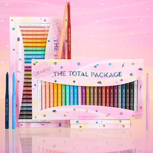ColourPop Crème Gel Liner vault The Total Package displays a full rainbow of retractable crème gel eyeliner pencils in a pastel pink box with holographic lettering, plus a few uncapped shades, set against a dreamy pink starry backdrop.